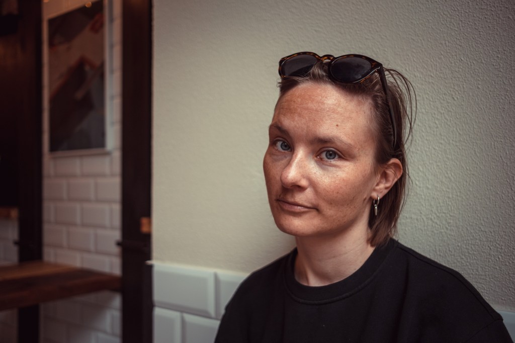 Bild von Alina, die recht ernst, aber freundlich und kompetent dreinblickt.